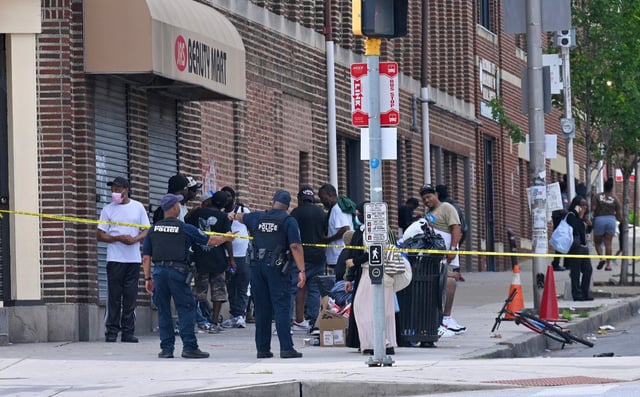 Baltimore City Police Department officers work on the corner of North Avenue and Pennsylvania Avenue, where at least 25 people were suspected of suffering overdoses. Many discovered lying unconscious on the street. The area is cordoned off as emergency responders work to provide aid and investigate the scene. (Kenneth K. Lam/Sun Staff)