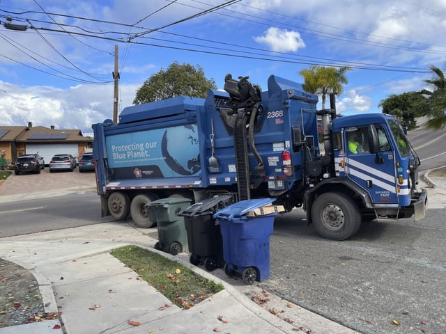 A “blue crew” from Republic Services picks up trash in front of a Chula Vista home Thursday morning. (Gary Warth / The San Diego Union-Tribune)