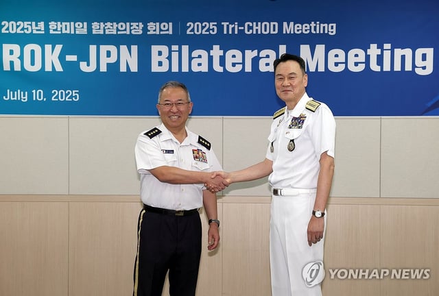 South Korean Joint Chiefs of Staff (JCS) Chairman Adm. Kim Myung-soo (R) poses for a photo with Gen. Yoshihide Yoshida, chief of the Japanese defense ministry's Joint Staff, during their meeting at the JCS' headquarters in Seoul on July 10, 2025, in this photo released by South Korea's JCS office. (PHOTO NOT FOR SALE) (Yonhap)