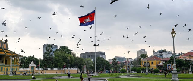 Doves fly near the Cambodian flag in front of the Royal Palace in Phnom Penh on May 3, 2023. - The 2023 Southeast Asian Games will be held from May 5 to 17 in Cambodia. (Photo by Mohd RASFAN / AFP) (Photo by MOHD RASFAN/AFP via Getty Images)