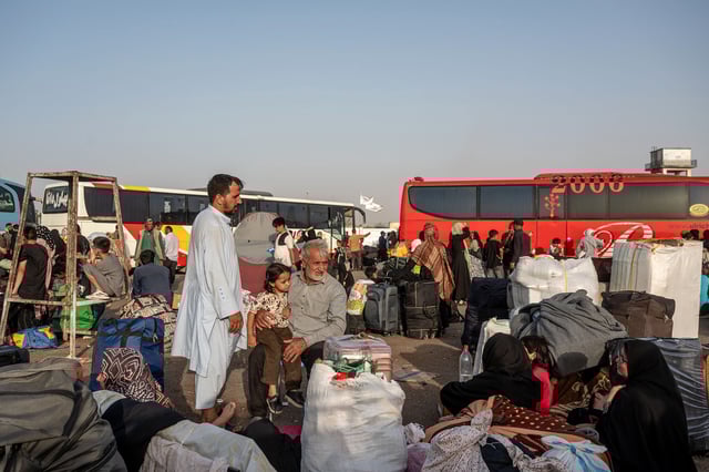 Afghans wait for shuttles and assistance at the overcrowded border reception area in Islam Qala, Afghanistan, near the Afghanistan-Iran border, on July 3.