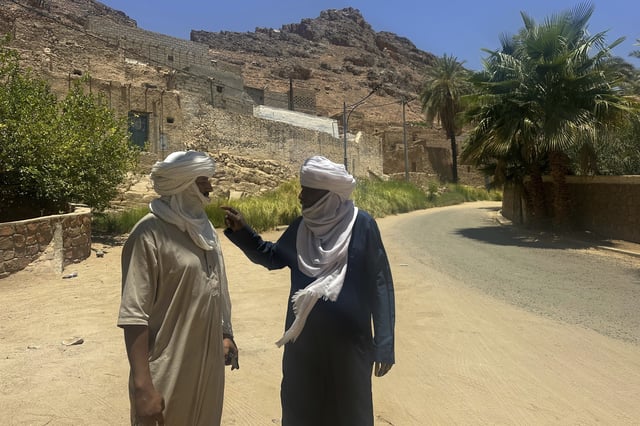 Tourist guide Ahmed Benhaoued, left, and Cheikh Hassani, director of Indigenous Institutional Dance of Sebeiba, meet in Djanet, a southeastern Algerian oasis town in the Sahara desert, on July 4, 2025. (AP Photo/Audrey Thibert)