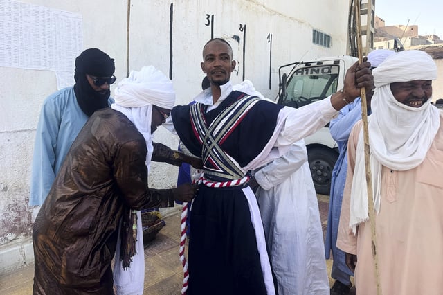 A dancer from El Mihan, Algeria prepares for the Sebeiba festival dance competition in Djanet, a southeastern Algerian oasis town in the Sahara desert, on July 6, 2025. (AP Photo/Audrey Thibert)