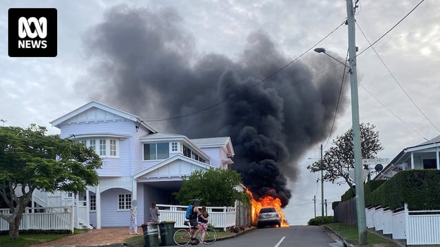 a burning car on a suburban street