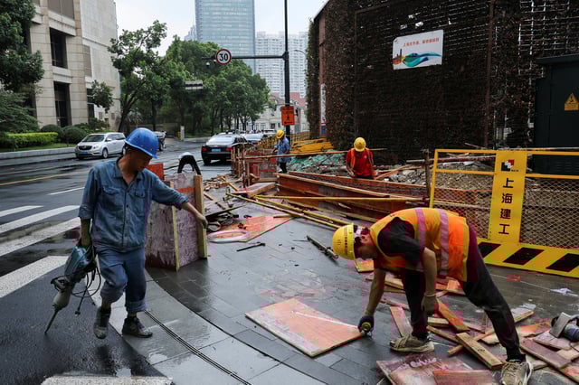 Construction workers operate on a construction site in Shanghai, China, July 10, 2025.  REUTERS/Go Nakamura/File Photo