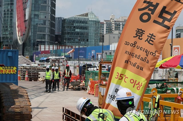 Workers at a construction site in Seoul take a break amid a heat wave on July 8, 2025. (Yonhap)
