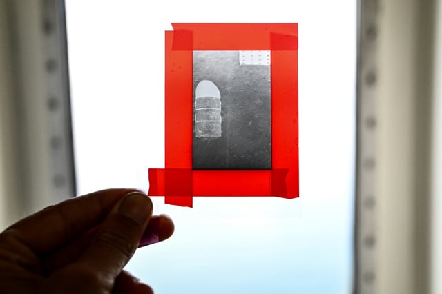 Un chercheur du CNRS montre le négatif d'un baril de déchets nucléaires photographié en 1985, à bord du navire scientifique Atalante avant son départ du port de Brest pour une mission scientifique, le 15 juin 2025 dans le Finistère