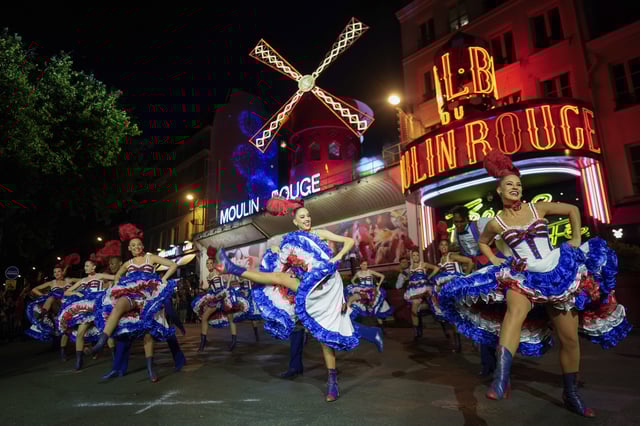 FILE - Dancers perform in front of the Moulin Rouge cabaret during the inauguration of the theatre's windmill in Paris, Friday, July 5, 2024. (AP Photo/Thibault Camus, File)