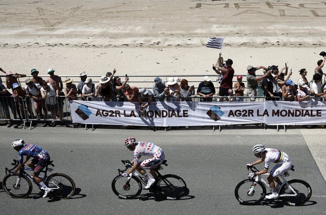 Cycling - Tour de France - Stage 7 - Saint-Malo to Mur-De-Bretagne Guerledan - Saint-Malo, France - July 11, 2025 Soudal Quick-Step's Valentin Paret Peintre, UAE Team Emirates XRG's Tadej Pogacar and UAE Team Emirates XRG's Tim Wellens in action at Pleneuf-Val-Andre as spectator cheer on during stage 7 REUTERS/Benoit Tessier