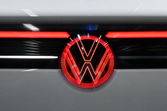 Das Logo von Volkswagen leuchtet in rot am Heck eines Autos auf der Messe „Auto Shanghai 2025“ (Archiv).