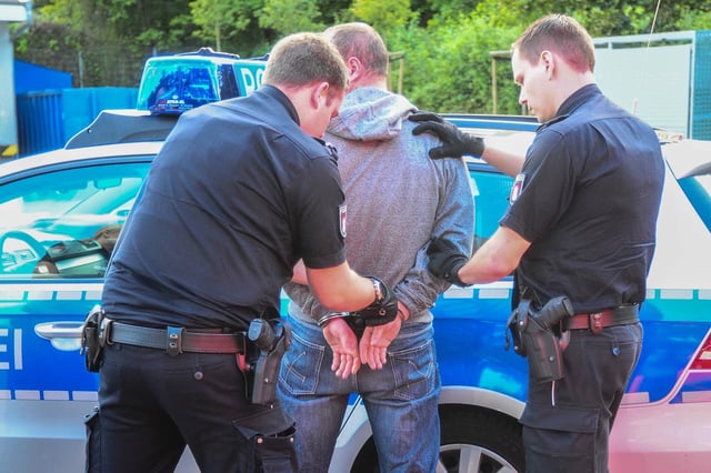 Polizeibeamte nehmen einen Mann fest (Symbolfoto).