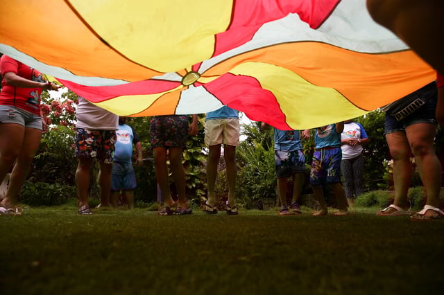 Children and instructors participate in a game prior to riding waves, as part of the Surftismo program, an alternative therapy for children with autism spectrum disorder diagnoses that uses surfing, in Chiltiupan, El Salvador August 14, 2022. REUTERS/Jose Cabezas