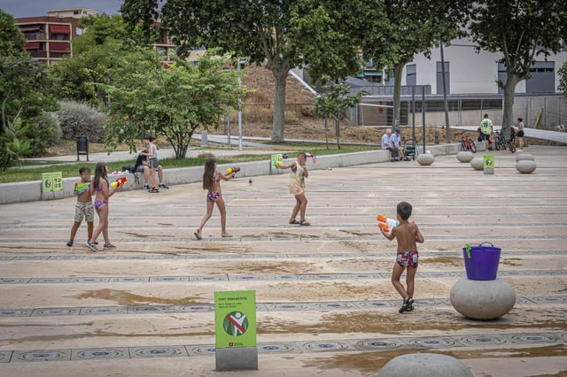 Niños jugando entre los surtidores apagados y hoy solo ornamentales de los primeros juegos de agua de Barcelona, en el parque Antoni Santiburcio