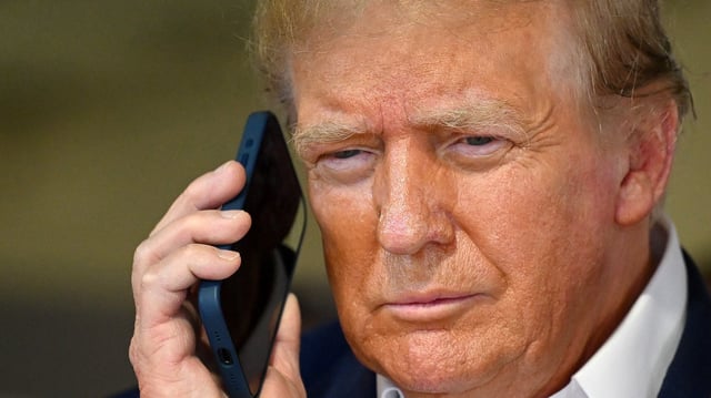 Donald Trump talks on the phone in the McLaren garage prior to the F1 Grand Prix of Miami at Miami International Autodrome on May 05, 2024 in Miami, Florida.