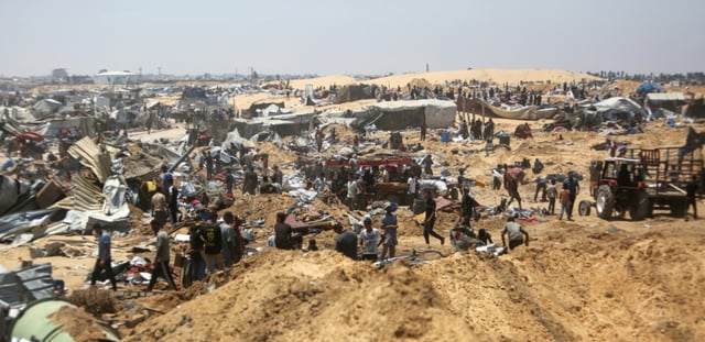 Des Palestiniens fouillent les débris d'un camp de déplacés près de Khan Younès, dans le sud de la bande de Gaza, au lendemain de ce que des témoins ont décrit comme une incursion de chars israéliens, le 11 juillet 2025