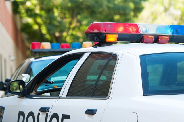 Careful, long exposure using tripod to capture flashing police car lights during daylight.