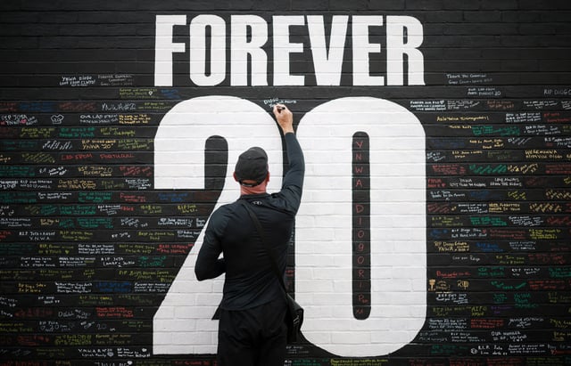 A fan adds a message to a memorial wall created near Anfield Stadium following the death of Liverpool soccer player Diogo Jota in Liverpool, Britain, July 9, 2025. REUTERS/Phil Noble/File Photo