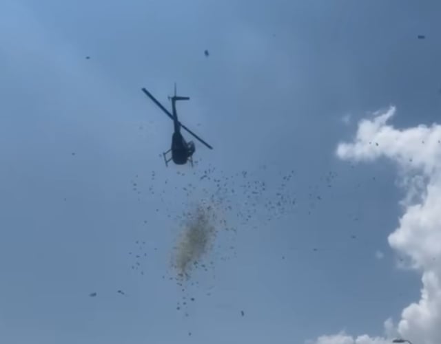 Money falls from a helicopter flying above Detroit, Mich., on June 27. The cash was sent by the family of a deceased local businessman whose dying wish was to shower his community in acts of generosity.