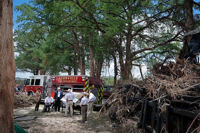 President Donald Trump, first lady Melania Trump and Texas Gov. Greg Abbott meet with local emergency services personnel Friday as they survey flood damage along the Guadalupe River in Kerrville, Texas. (Chip Somodevilla/Getty Images)