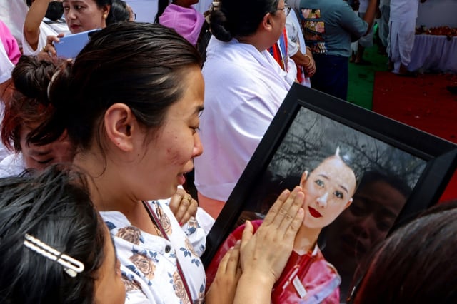 Kongbrailatpam Gitanjali Sharma, sœur d'une membre d'équipage du vol AI171 d'Air India, pleure en caressant son portrait lors de la cérémonie funéraire à Imphal le 22 juin 2022