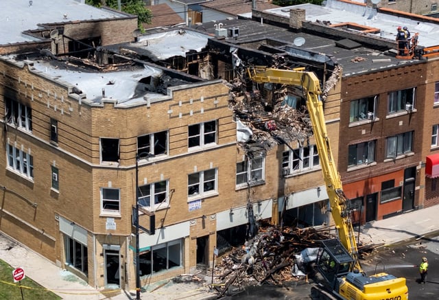 A demolition crew knocks down damaged sections of a building after an overnight fire killed four, June 26, 2025, in the 5200 block of West North Avenue in Chicago&#39;s Austin neighborhood. (Brian Cassella/Chicago Tribune)