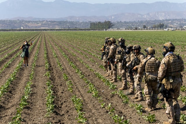 Une femme fait face à des agents fédéraux lors d'une descente de la police de l'immigration à Camarillo, en Californie, le 10 juillet 2025