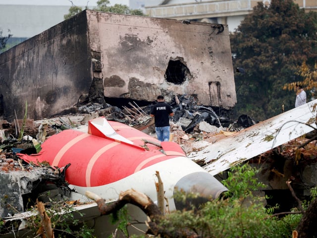 FILE PHOTO: A firefighter stands next to the crashed Air India Boeing 787-8 Dreamliner aircraft, in Ahmedabad, India, June 13, 2025. REUTERS/Adnan Abidi/File Photo