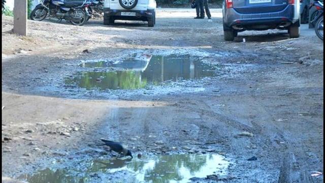 Commuters-having-a-bumpy-ride-on-the-road-filled-with-potholes-Sant-Arora-HT-Photo
