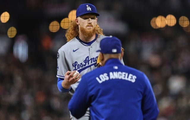 Dodgers starting pitcher Dustin May, left, hands the ball to Manager Dave Roberts as he is replaced during the fifth inning of their game against the San Francisco Giants on Friday night in San Francisco. May was charged with seven runs on five hits and four walks in 4-2/3 innings in an 8-7 loss. (AP Photo/Godofredo A. Vásquez)