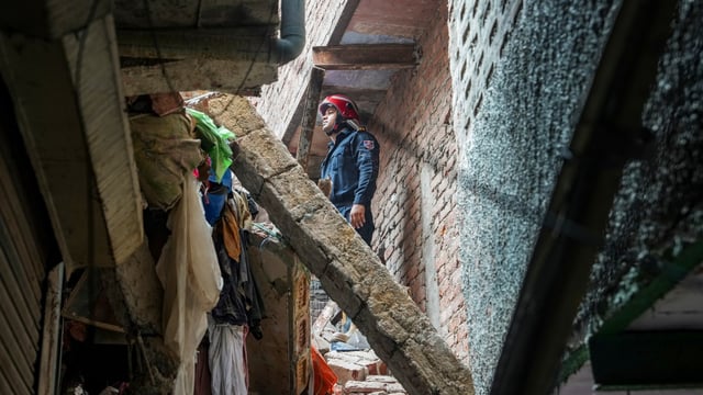 A fireman stands amid debris during a rescue operation after a four-story building collapsed in the Welcome area of New Delhi on Saturday, July 12, 2025.