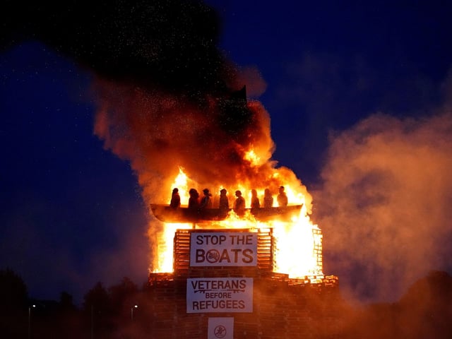 Effigies of migrants in a boat burn atop a bonfire at Moygashel, County Tyrone, Northern Ireland, ahead of events to mark the Twelfth of July, Thursday July 10, 2025. (Niall Carson/PA via AP)