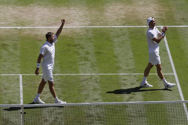 Tennis - Wimbledon - All England Lawn Tennis and Croquet Club, London, Britain - July 12, 2025 Britain's Lloyd Glasspool and Julian Cash celebrate winning the men's doubles final against Australia's Rinky Hijikata and Netherlands' David Pel REUTERS/Andrew Couldridge