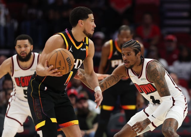 Jalen Green #4 of the Houston Rockets defends against Devin Booker #1 of the Phoenix Suns during the first half of the game at Toyota Center on March 12, 2025 in Houston.