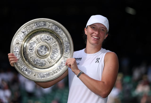 Tennis - Wimbledon - All England Lawn Tennis and Croquet Club, London, Britain - July 12, 2025 Poland's Iga Swiatek celebrates with the trophy after winning the women's singles final at Wimbledon against Amanda Anisimova of the U.S. REUTERS/Toby Melville