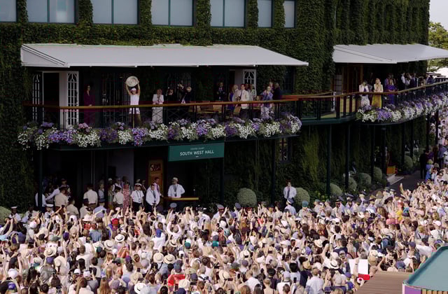 Tennis - Wimbledon - All England Lawn Tennis and Croquet Club, London, Britain - July 12, 2025 Poland's Iga Swiatek celebrates on the balcony with the trophy after winning the women's singles final against Amanda Anisimova of the U.S. REUTERS/Andrew Couldridge     TPX IMAGES OF THE DAY