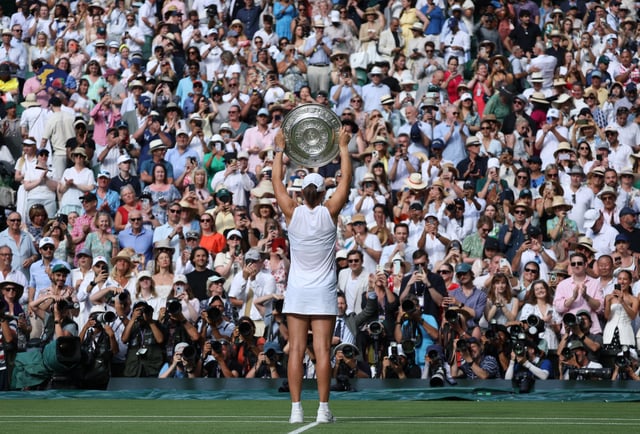 Tennis - Wimbledon - All England Lawn Tennis and Croquet Club, London, Britain - July 12, 2025 Poland's Iga Swiatek celebrates with the trophy after winning the women's singles final at Wimbledon against Amanda Anisimova of the U.S. REUTERS/Toby Melville