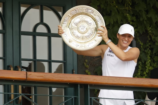 Jul 12, 2025; Wimbledon, United Kingdom; Iga Swiatek (POL) stands on the South West Hall balcony holding the Venus Rosewater Dish after her match against Amanda Anisimova (USA)(not pictured) in the ladies' singles championship on day thirteen of The Championships Wimbledon 2025 at All England Lawn Tennis and Croquet Club. Mandatory Credit: Geoff Burke-Imagn Images