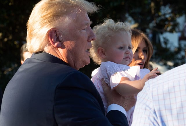 President Donald Trump holds a baby during the Congressional Picnic on the South Lawn of the White House on June 21, 2019.