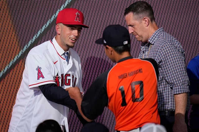 Zach Neto, left, shakes hands with a fan after being selected by the Angels with the 13th pick of the 2022 MLB baseball draft, Sunday, July 17, 2022, in Los Angeles. (AP Photo/Jae C. Hong )