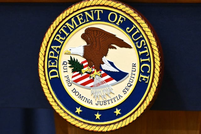 The seal of the US Department of Justice is seen before the start of a press conference on health care fraud enforcement at the Department of Justice in Washington, DC on June 30, 2025.