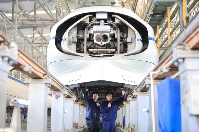 Mechanics checking a bullet train at a maintenance centre in Nanjing, eastern China&#39;s Jiangsu province, January 13, 2025.