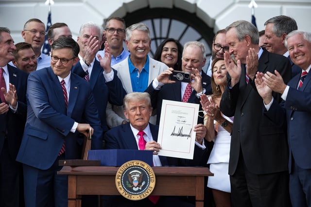 President Donald Trump signs his tax and budget bill from the South Lawn of the White House on July 4, in Washington, DC.