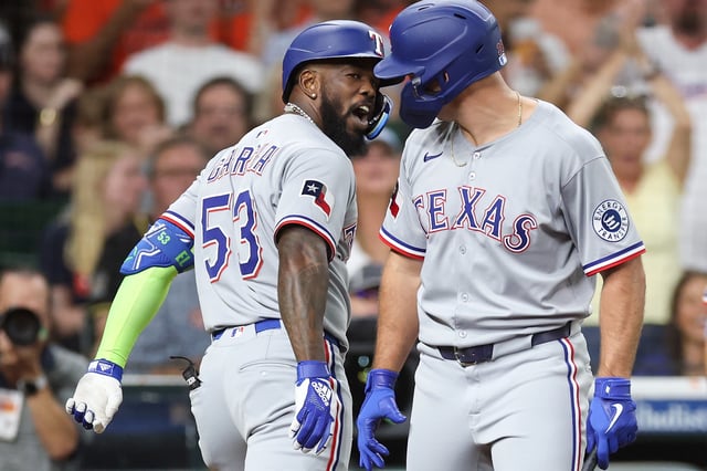 HOUSTON, TEXAS - JULY 11: Adolis Garcia #53 of the Texas Rangers is congratulated by Wyatt Langford #36 after hitting a solo home run in the third inning against the Houston Astros at Daikin Park on July 11, 2025 in Houston, Texas.
