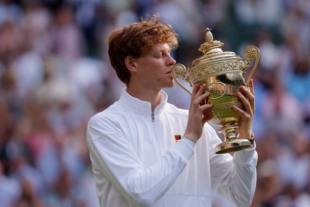 Tennis - Wimbledon - All England Lawn Tennis and Croquet Club, London, Britain - July 13, 2025 Italy's Jannik Sinner celebrates with the trophy after winning the men's final against Spain's Carlos Alcaraz REUTERS/Andrew Couldridge
