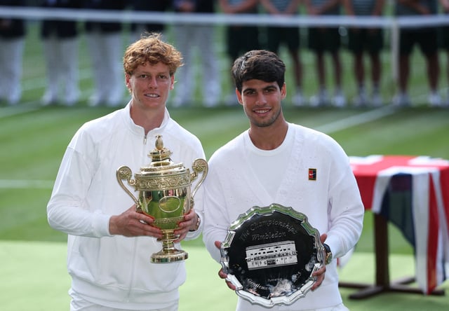 Tennis - Wimbledon - All England Lawn Tennis and Croquet Club, London, Britain - July 13, 2025 Italy's Jannik Sinner celebrates with the trophy after winning the men's final alongside runner up Spain's Carlos Alcaraz REUTERS/Toby Melville