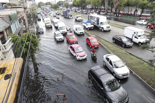Vehículos cruzan por una avenida inundada por las fuertes lluvias en Ciudad de México. EFE/ Mario Guzmán