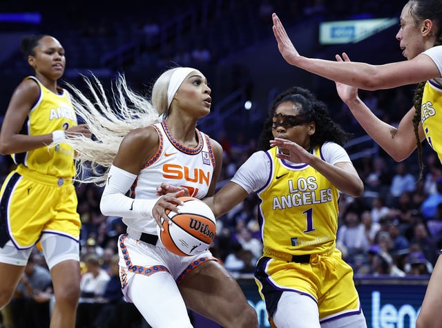 DiJonai Carrington #21 of the Connecticut Sun controls the ball against Zia Cooke #1 of the Los Angeles Sparks in the first half at Crypto.com Arena on September 10, 2024 in Los Angeles, California.