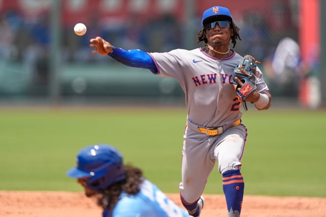 New York Mets second baseman Luisangel Acuna (2) throws to first for the double play hit into by Kansas City Royals&#39; Bobby Witt Jr. after forcing Jonathan India (6) out at second during the third inning of a baseball game, Sunday, July 13, 2025, in Kansas City, Mo. (AP Photo/Charlie Riedel)