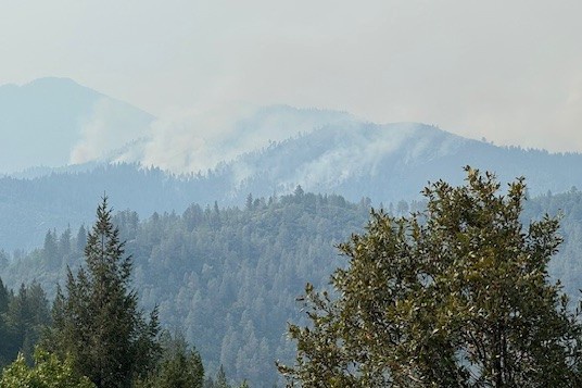 Smoke rises from the southern edge of the Green Fire, looking north from Backbone Road.
