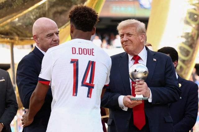 U.S. President Donald Trump holds the young player of the tournament trophy as FIFA president Gianni Infantino greets Paris St Germain's Desire Doue after Chelsea won against Paris St Germain in the FIFA Club World Cup final, at the MetLife Stadium in East Rutherford, New Jersey, U.S., July 13, 2025. REUTERS/Kevin Lamarque/Pool